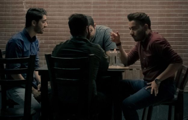 Men gathered around a table talking