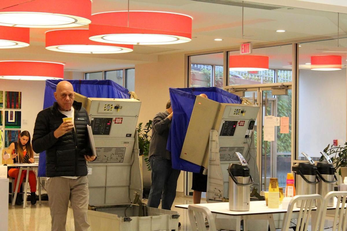 Man holding coffee walking in voting area