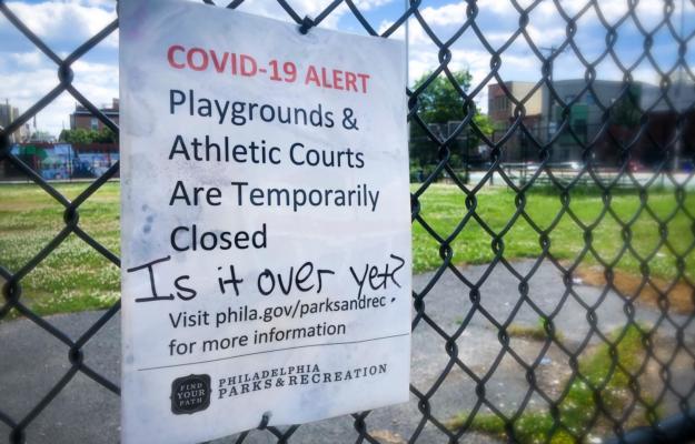 Sign affixed to fencing at Chew Playground in South Philly that says the park is closed with graffiti asking, "Is it over yet?" scrawled onto it.