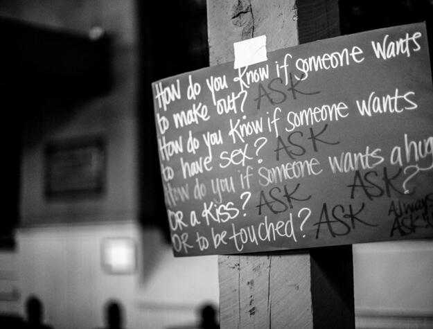 A handwritten placard that reads, "How do you know if someone wants to make out? Ask. How do you know if someone wants to have sex? Ask. How do you know if someone wants to hug or a kiss or to be touched? Ask, ask, ask."