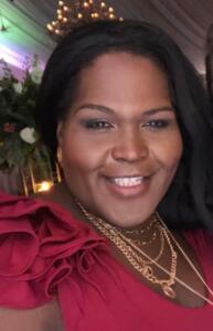 Aeryanah smiling while wearing a formal dress and glam jewelry.