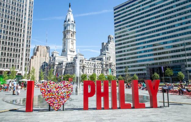 Temporary art installation in LOVE Park that reads I HEART ICON PHILLY with City Hall and Love Park's fountains in the background.