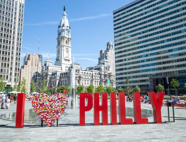 Temporary art installation in LOVE Park that reads I HEART ICON PHILLY with City Hall and Love Park's fountains in the background.